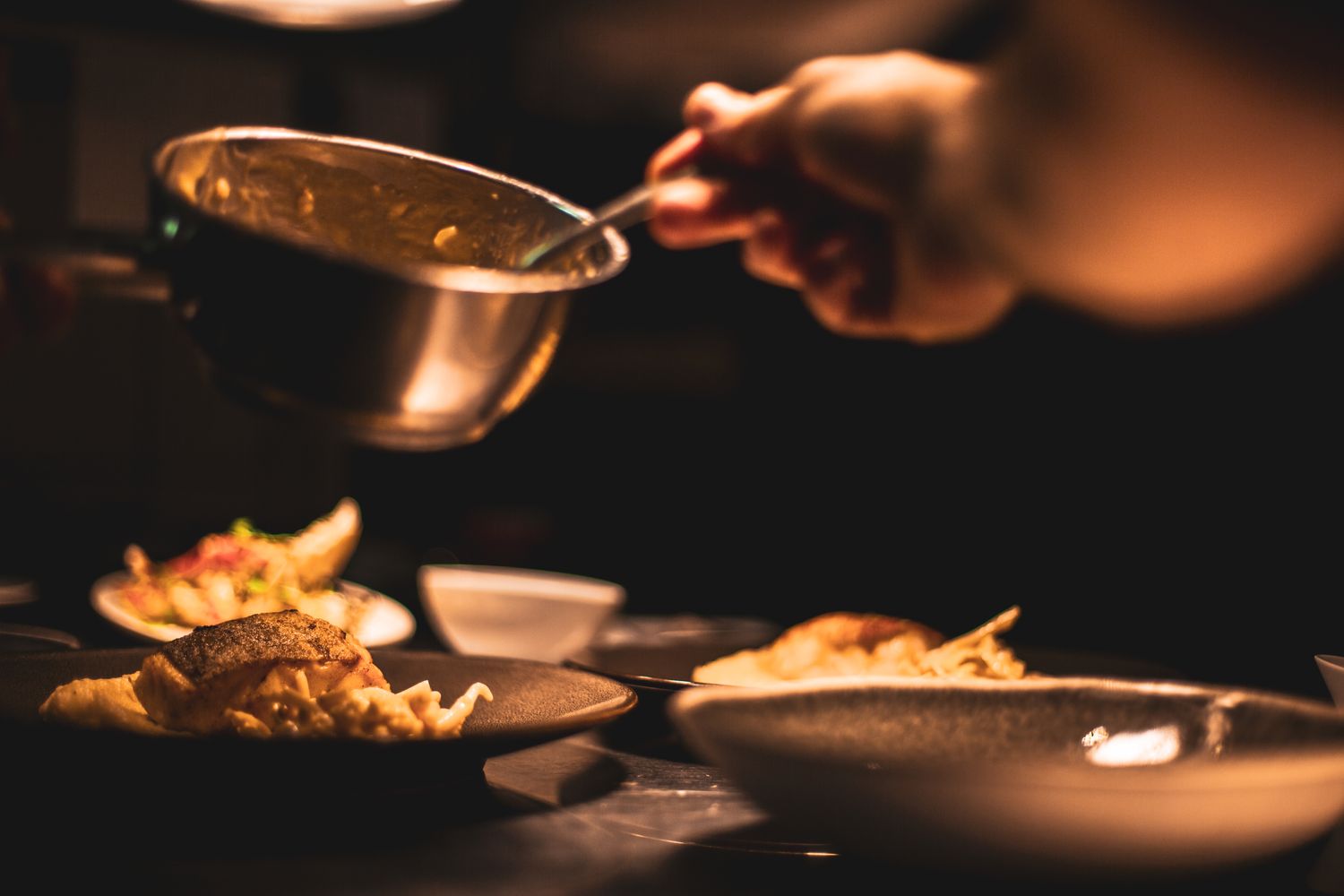 A chef plating a dish in a restaurant kitchen